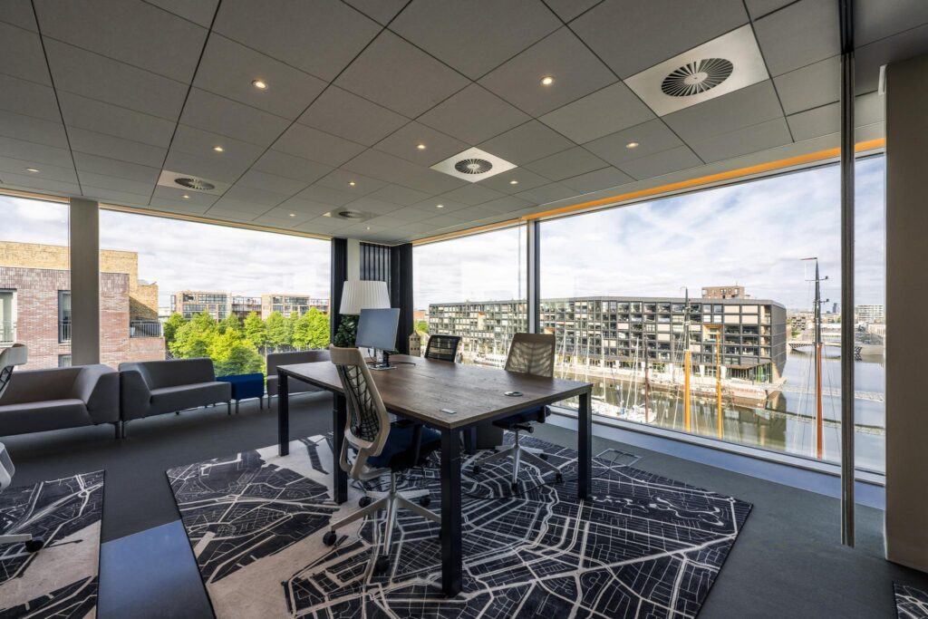 Modern office space with large windows overlooking the Krijn Taconiskade harbor area.